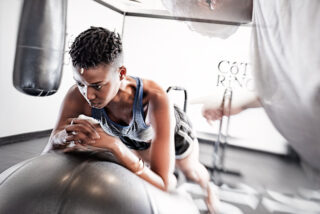femme en tenue sportive s'entrainant avec son coach à coté