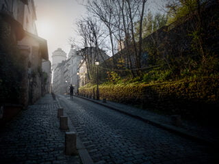 A la levée du soleil sur une route pavée de Montmartre une joggeuse courre seule