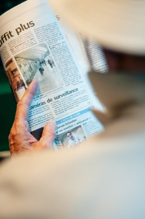 Sous surveillance homme lisant un article de journal sur les caméras de surveillance