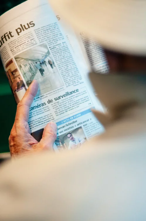 homme lisant un article de journal sur les caméras de surveillance