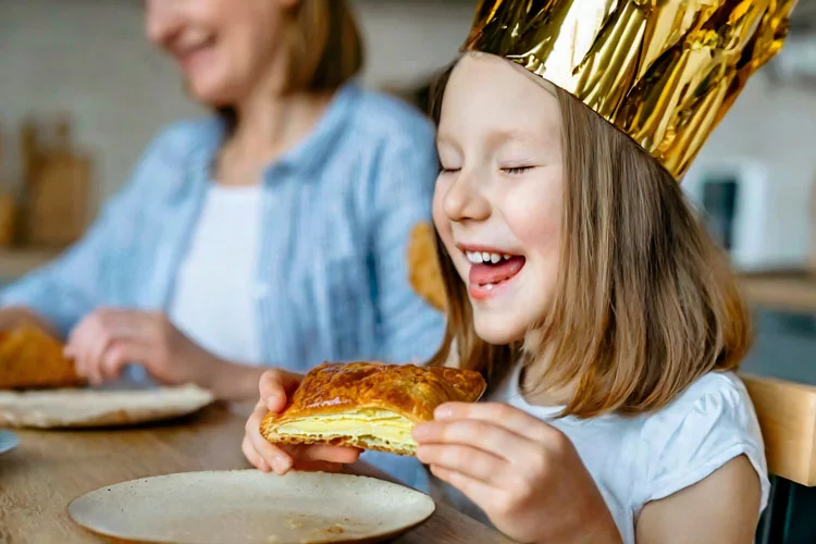 une petite fille s'apprête à manger sa galette des rois